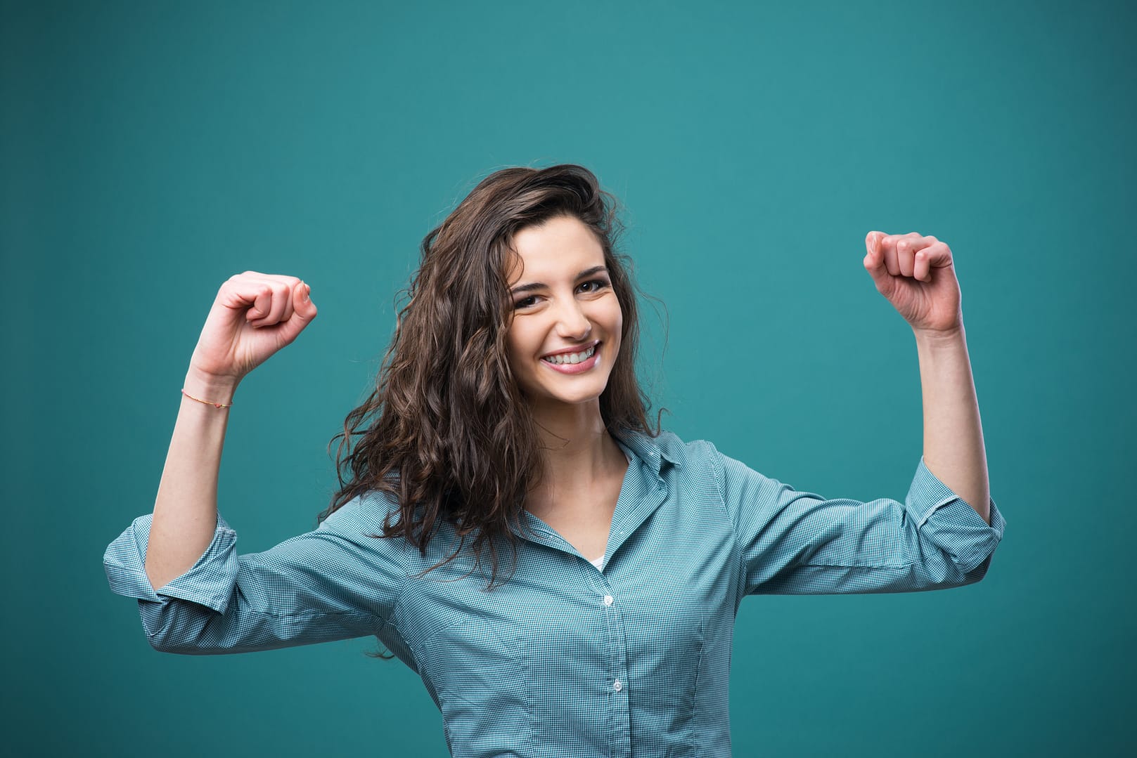 Cheerful woman with raised fists Girl looking happy and empowered